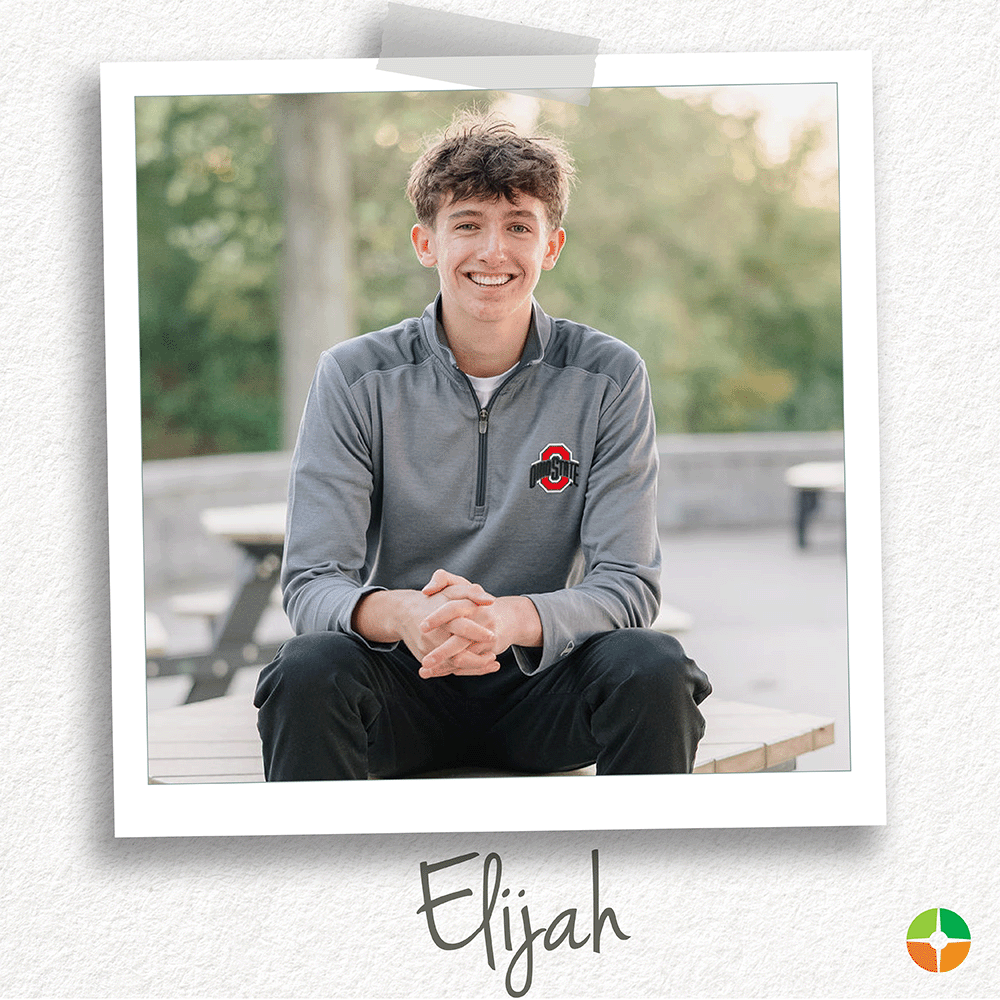 Polaroid-style photo of a smiling young man sitting outdoors on a bench with trees in the background. He wears a gray Ohio State quarter-zip pullover and black pants. The name “Elijah” appears in gray script at the bottom, with a small logo in the corner.