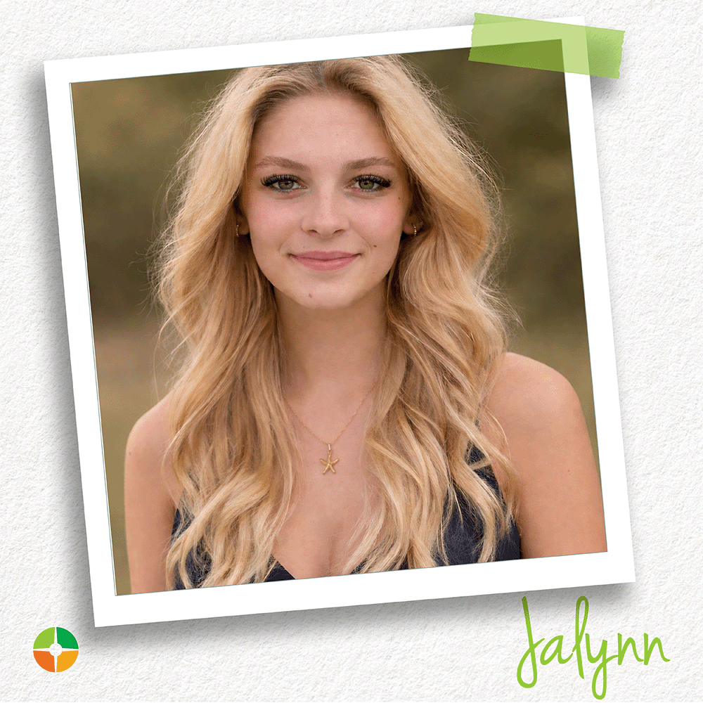 A young woman with long blonde hair smiles warmly at the camera in an outdoor portrait. Wearing a dark top and a starfish necklace, she stands against a softly blurred natural background. The image highlights her confident expression and relaxed, approachable demeanor. A young woman with long blonde hair smiles warmly at the camera in an outdoor portrait. Wearing a dark top and a starfish necklace, she stands against a softly blurred natural background. The image highlights her confident expression and relaxed, approachable demeanor.