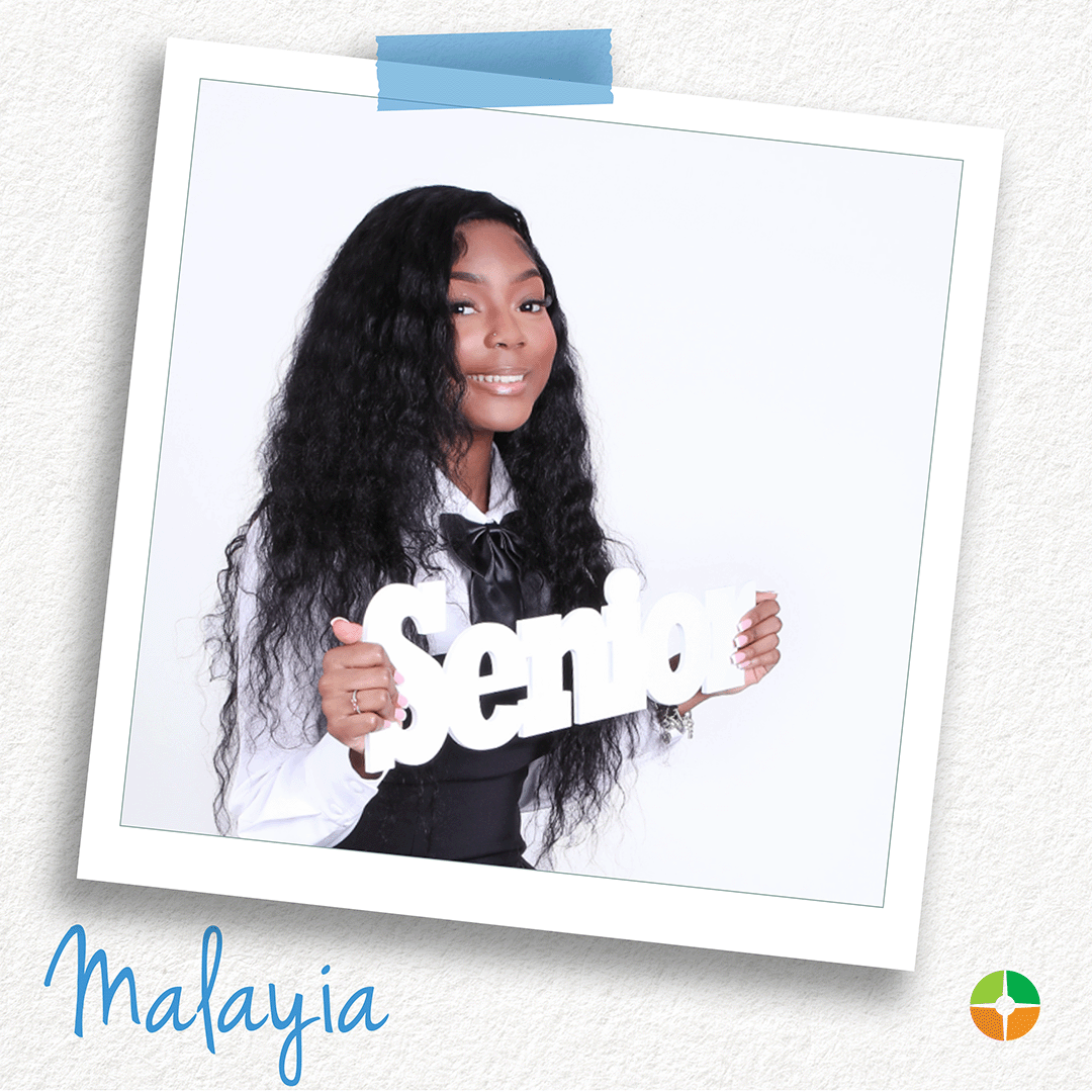 A young woman with long, wavy hair smiles while holding a “Senior” sign. Dressed in a black-and-white outfit, she poses against a clean white background. The portrait celebrates a milestone achievement and captures her confidence, pride, and excitement for the future. A young woman with long, wavy hair smiles while holding a “Senior” sign. Dressed in a black-and-white outfit, she poses against a clean white background. The portrait celebrates a milestone achievement and captures her confidence, pride, and excitement for the future.