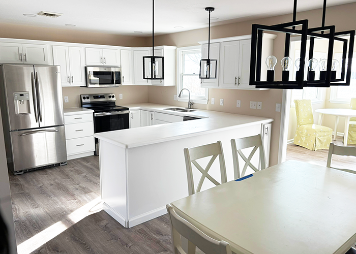 Kitchen and eat‑in dining area at 605 Gronlund featuring new stainless‑steel appliances, light cabinetry, and an open layout.